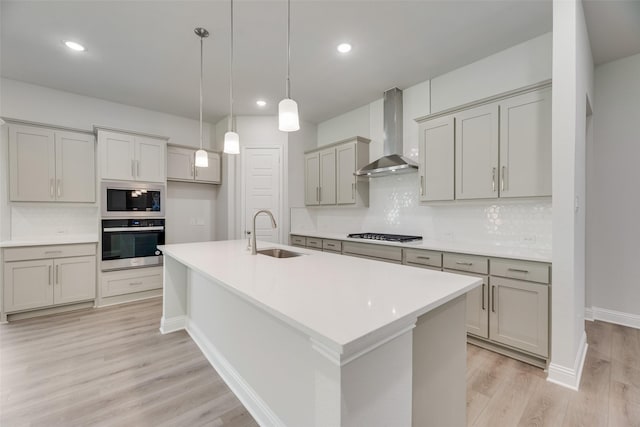 7111 Manhattan Dr, Rowlett, TX 75088 - kitchen featuring wall chimney range hood, stainless steel appliances, a sink, light wood-style floors, and tasteful backsplash