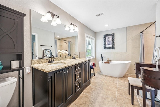 635 Old Justin Rd, Argyle, TX 76226 - bathroom featuring a shower stall, tile patterned floors, a freestanding bath, double vanity, and toilet