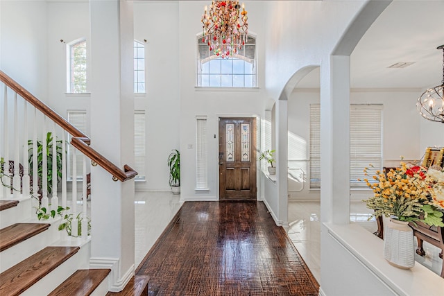 14723 Alstone Dr, Frisco, TX 75035 - entrance foyer featuring stairs, arched walkways, a chandelier, a towering ceiling, and wood finished floors