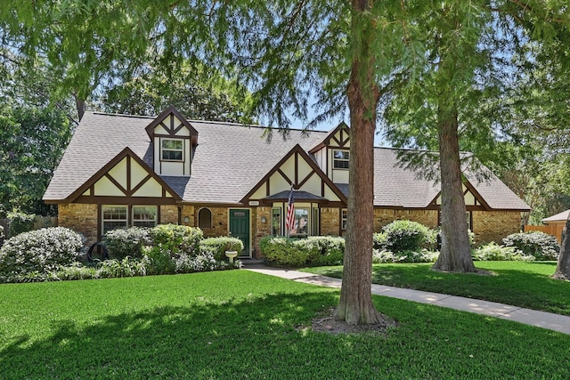 4401 Longacres Ct, Arlington, TX 76016 - tudor home featuring a front lawn, a shingled roof, and brick siding