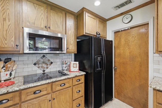 4401 Longacres Ct, Arlington, TX 76016 - kitchen with black appliances, backsplash, light stone countertops, brown cabinetry, and crown molding
