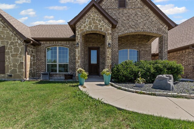 101 Cedar Mountain Dr, Weatherford, TX 76085 - entrance to property featuring brick siding, a lawn, stone siding, and roof with shingles