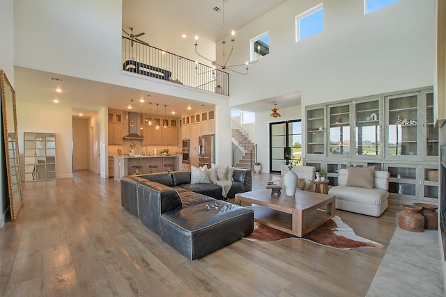 10356 Wild Rose Cir, Forney, TX 75126 - living room featuring a high ceiling, stairs, light wood finished floors, and a chandelier