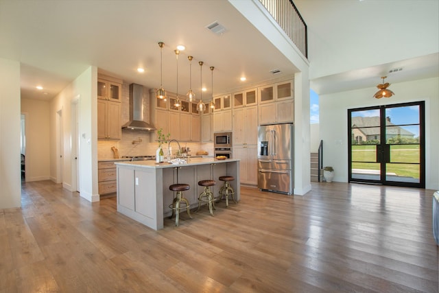 10356 Wild Rose Cir, Forney, TX 75126 - kitchen featuring stainless steel appliances, wall chimney range hood, a breakfast bar area, light wood-style floors, and recessed lighting