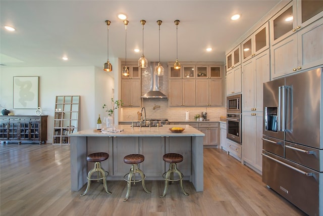 10356 Wild Rose Cir, Forney, TX 75126 - kitchen with appliances with stainless steel finishes, wall chimney range hood, a sink, light wood-style flooring, and recessed lighting