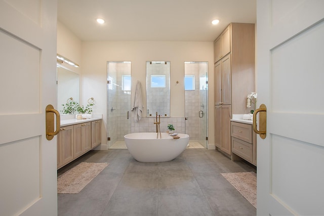10356 Wild Rose Cir, Forney, TX 75126 - bathroom with a soaking tub, a shower stall, two vanities, finished concrete floors, and recessed lighting