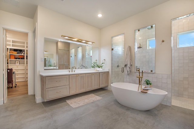 10356 Wild Rose Cir, Forney, TX 75126 - bathroom featuring tiled shower, vanity, a freestanding tub, and a walk in closet
