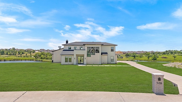 10356 Wild Rose Cir, Forney, TX 75126 - view of front facade with a front yard, a water view, stucco siding, and a chimney