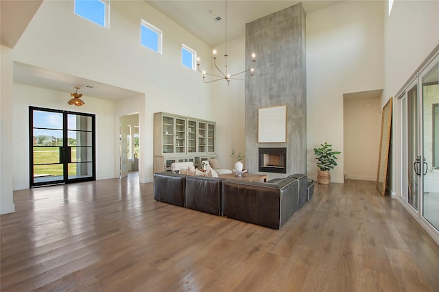 10356 Wild Rose Cir, Forney, TX 75126 - living area with a towering ceiling, wood finished floors, a chandelier, a large fireplace, and healthy amount of natural light