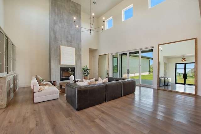 10356 Wild Rose Cir, Forney, TX 75126 - living area with a high ceiling, a fireplace, wood finished floors, a chandelier, and baseboards