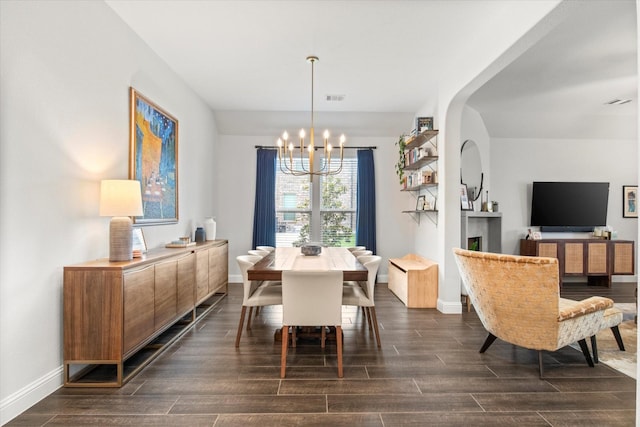 dining area with a chandelier, dark wood finished floors, and baseboards