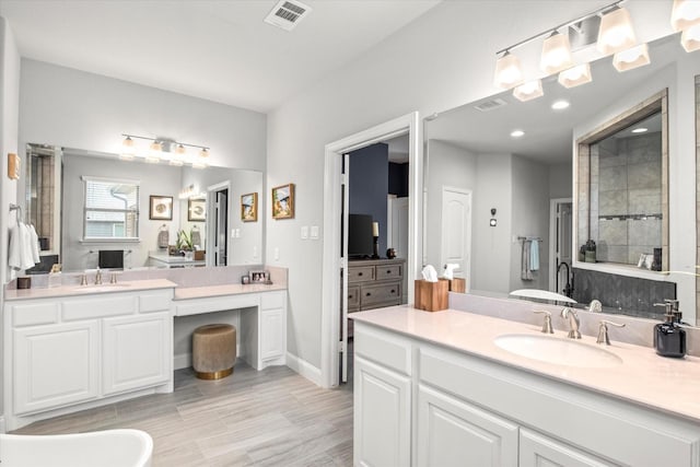 full bath with a shower stall, two vanities, wood finished floors, recessed lighting, and baseboards