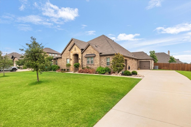 french country style house with brick siding, driveway, an attached garage, and a shingled roof
