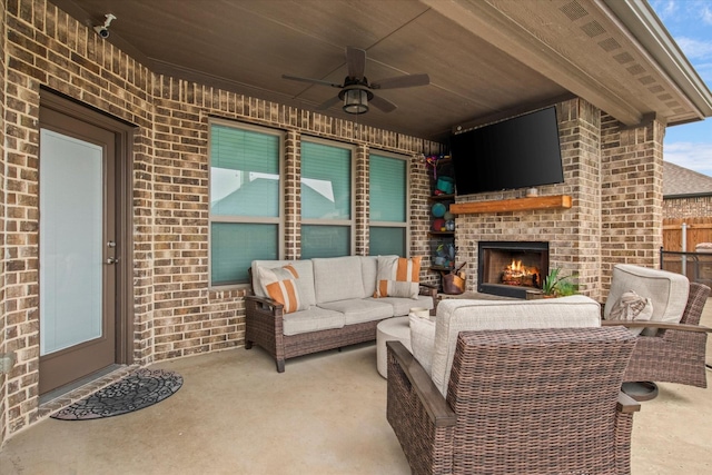 view of patio / terrace featuring ceiling fan and an outdoor living space with a fireplace