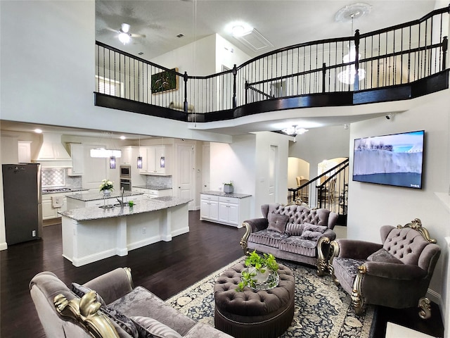11424 Barcelona Ln, Frisco, TX 75035 - living room with dark wood-style flooring, stairs, a towering ceiling, and arched walkways