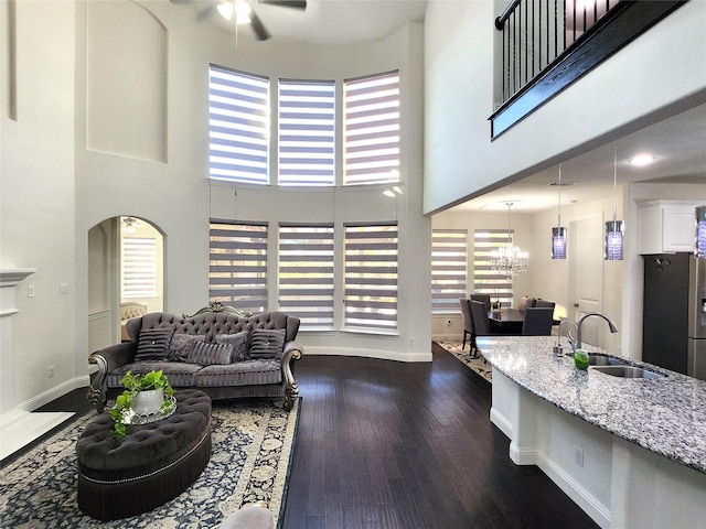 11424 Barcelona Ln, Frisco, TX 75035 - living area with a towering ceiling, ceiling fan, a chandelier, healthy amount of natural light, and dark wood-style floors