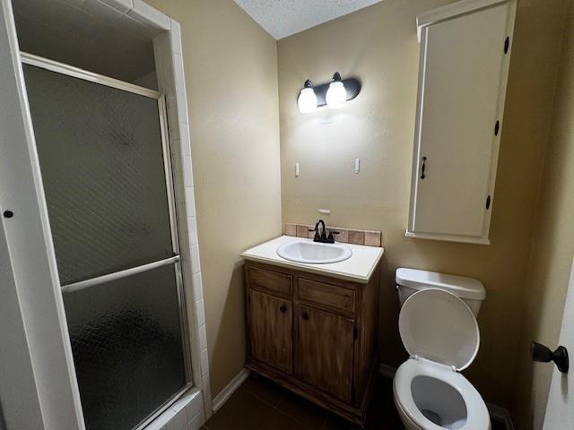 7625 Deaver Dr, North Richland Hills, TX 76180 - bathroom featuring a stall shower, toilet, tile patterned flooring, and vanity