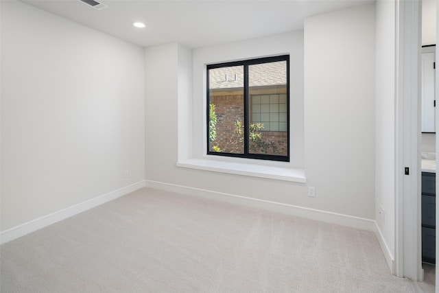spare room featuring light colored carpet, baseboards, and recessed lighting