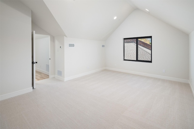 additional living space featuring vaulted ceiling, light colored carpet, and baseboards