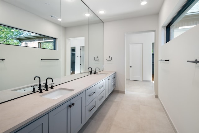 full bathroom featuring plenty of natural light, double vanity, recessed lighting, and baseboards