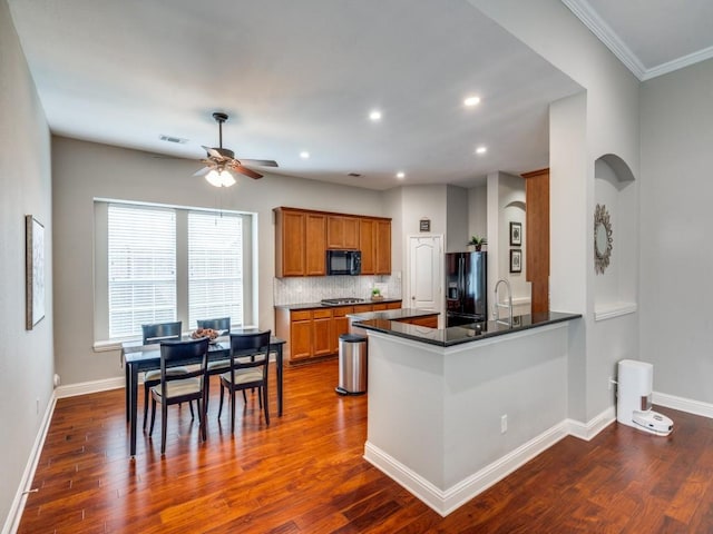 1710 Redcedar Dr, Wylie, TX 75098 - kitchen with black appliances, brown cabinets, ceiling fan, dark wood-style flooring, and recessed lighting