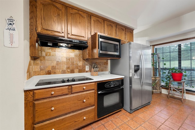 444 Lost Forest Ln, Marlin, TX 76661 - kitchen with black appliances, under cabinet range hood, brown cabinetry, and light countertops