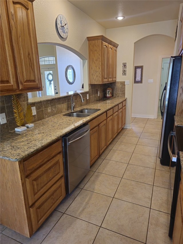 16 Cedar Bayou Cir, Pottsboro, TX 75076 - kitchen with a sink, stainless steel appliances, decorative backsplash, arched walkways, and light stone countertops