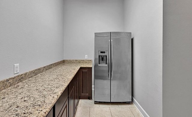 17015 Salado Dr, Woodway, TX 76712 - kitchen featuring stainless steel fridge, dark brown cabinetry, light stone counters, and light tile patterned floors