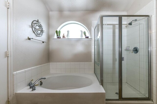 918 Telluride Dr, Arlington, TX 76001 - bathroom with a shower stall, a bath, and a textured ceiling