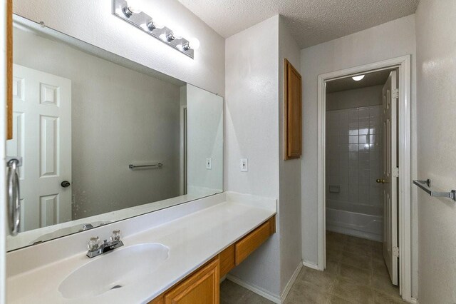 918 Telluride Dr, Arlington, TX 76001 - bathroom featuring vanity, tile patterned floors, baseboards, and a textured ceiling