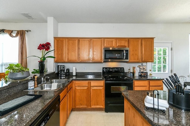 918 Telluride Dr, Arlington, TX 76001 - kitchen featuring stainless steel microwave, electric range, dishwasher, brown cabinetry, and a textured ceiling