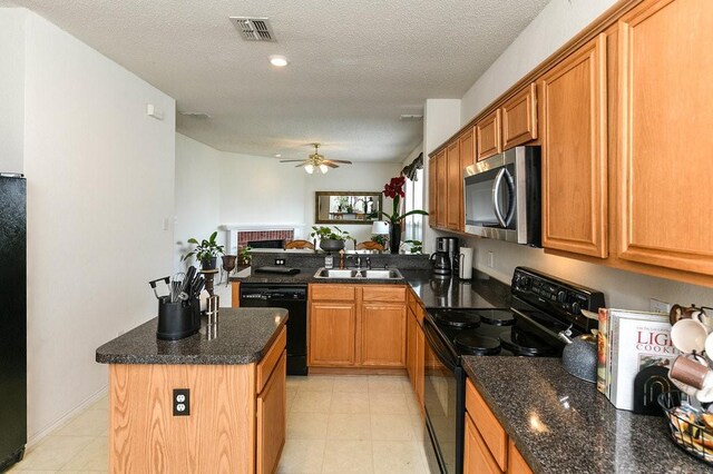 918 Telluride Dr, Arlington, TX 76001 - kitchen with black appliances, a sink, ceiling fan, a center island, and brown cabinets