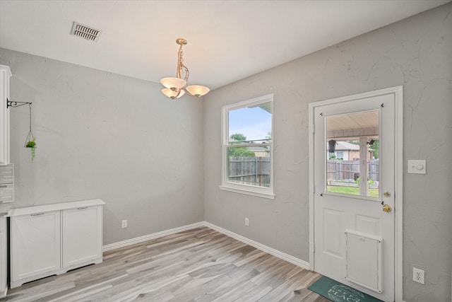 1612 Marble Cove Ln, Denton, TX 76210 - unfurnished dining area with light wood finished floors, a chandelier, and baseboards