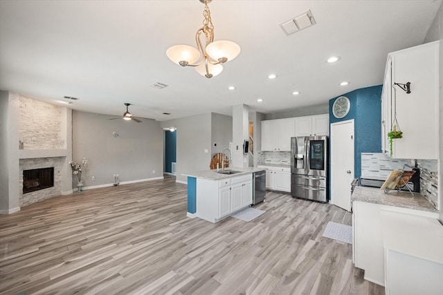 1612 Marble Cove Ln, Denton, TX 76210 - kitchen with stainless steel appliances, a sink, backsplash, open floor plan, and white cabinetry