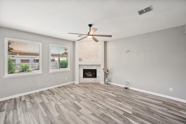 1612 Marble Cove Ln, Denton, TX 76210 - unfurnished living room with a ceiling fan, wood finished floors, a stone fireplace, and baseboards