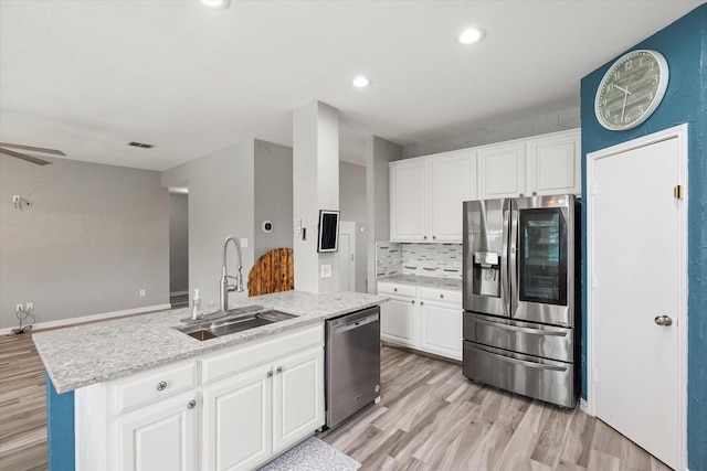 1612 Marble Cove Ln, Denton, TX 76210 - kitchen with stainless steel appliances, a sink, light wood finished floors, white cabinetry, and recessed lighting