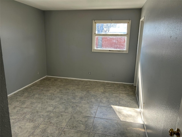 spare room with baseboards