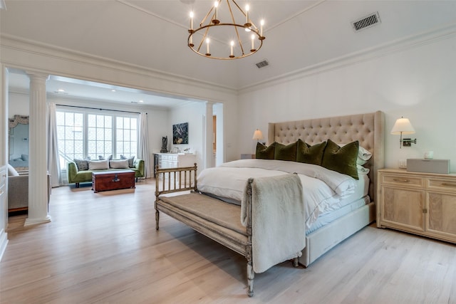bedroom featuring decorative columns, light wood finished floors, ornamental molding, and a chandelier