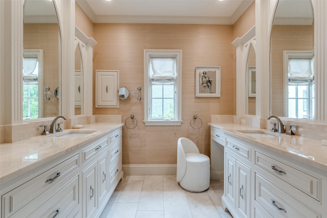 bathroom featuring two vanities, baseboards, and tiled shower