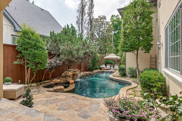view of swimming pool featuring a fenced backyard, a patio area, and a pool with connected hot tub