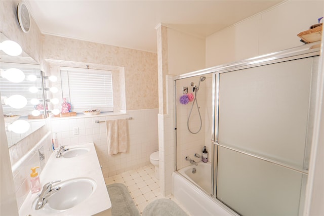831 Plum St, Graham, TX 76450 - full bath featuring a wainscoted wall, tile walls, shower / bath combination with glass door, toilet, and wallpapered walls