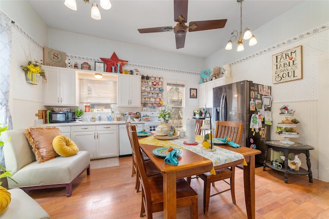 517 W College Ave, Coleman, TX 76834 - dining space with wallpapered walls, a chandelier, a wainscoted wall, ceiling fan, and light wood finished floors
