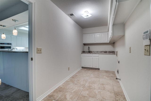 3824 Wyeth Dr, Plano, TX 75023 - laundry room with electric dryer hookup, cabinet space, baseboards, and wet bar