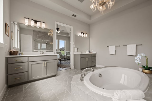 bathroom with a shower stall, two vanities, a bath, a chandelier, and marble finish flooring