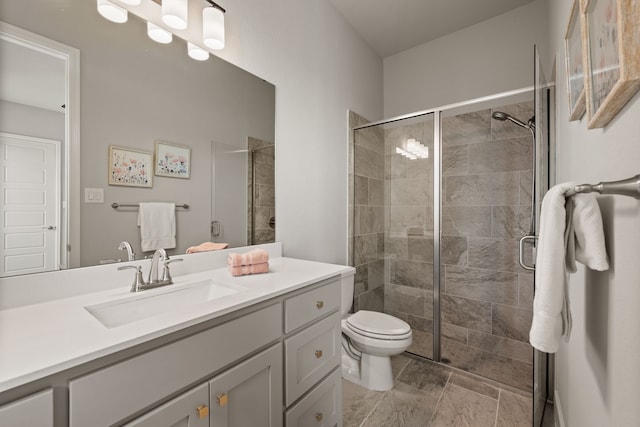 bathroom with a stall shower, vanity, and toilet