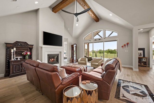 living room featuring a glass covered fireplace, beamed ceiling, recessed lighting, ceiling fan, and baseboards