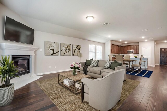 1910 Blackbird Ln, Princeton, TX 75407 - living area featuring dark wood-style flooring, recessed lighting, a glass covered fireplace, and baseboards