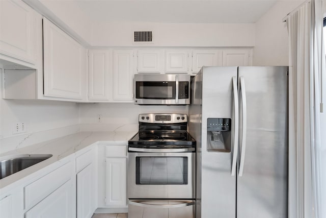 4325 Madera Rd, Irving, TX 75038 - kitchen featuring stainless steel appliances, white cabinets, and light stone countertops