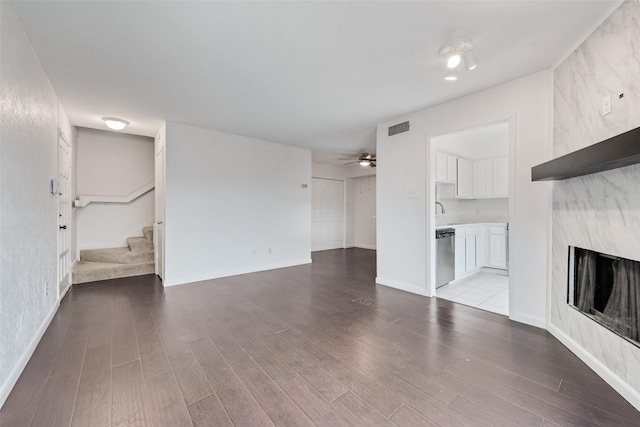 4325 Madera Rd, Irving, TX 75038 - unfurnished living room with wood finished floors, a premium fireplace, stairs, a ceiling fan, and baseboards