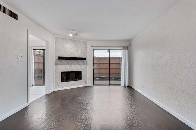 4325 Madera Rd, Irving, TX 75038 - unfurnished living room with a textured wall, wood finished floors, baseboards, and a premium fireplace
